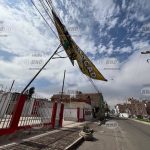 Letrero suspendido sobre cables pone en riesgo a transeúntes